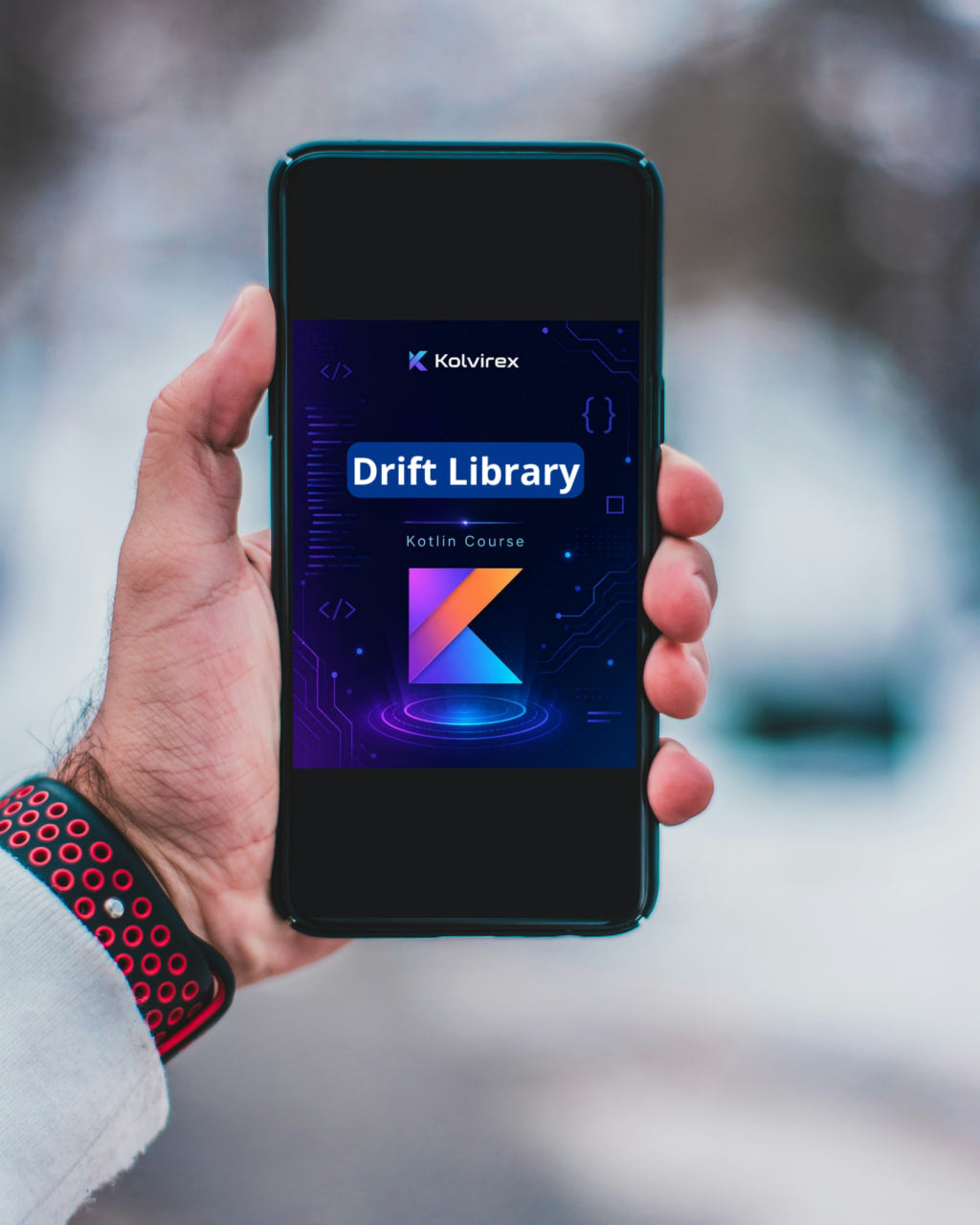 Hand holding a smartphone displaying the Kolvirex Drift Library app with a blurred outdoor background.